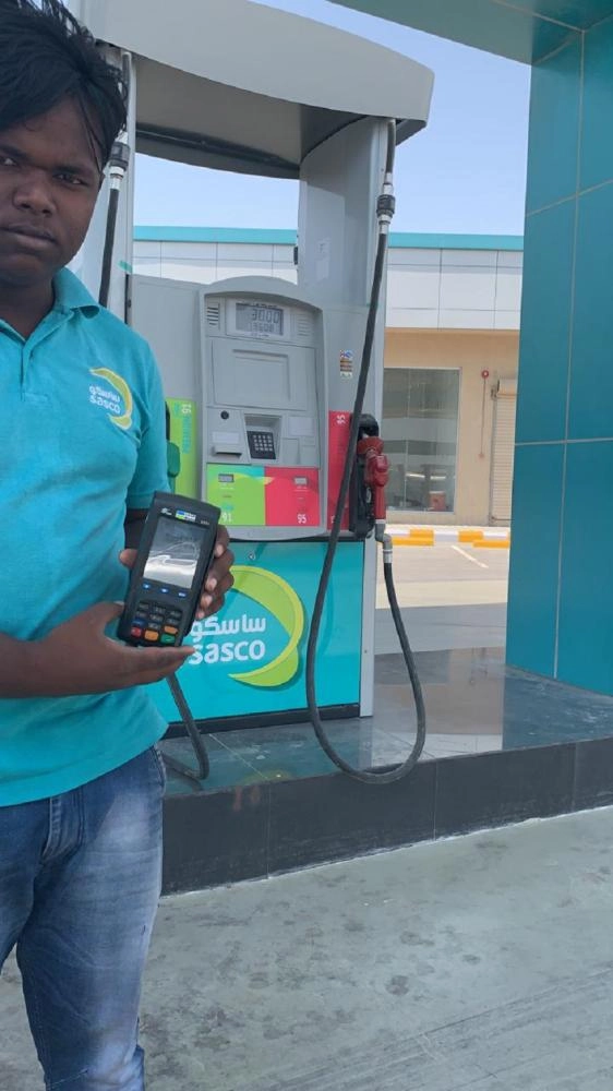عامل بإحدى المحطات يستخدم جهاز الدفع (مكة)