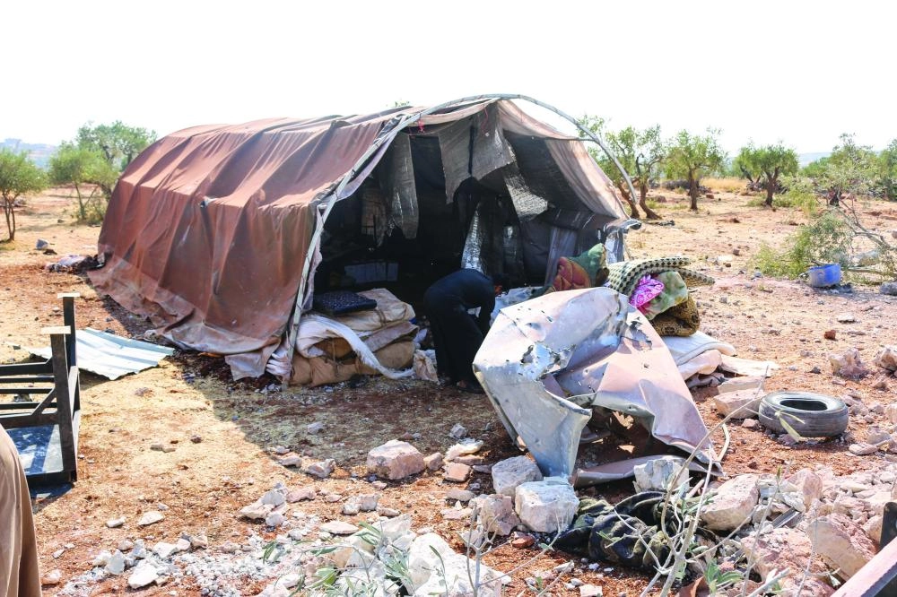 



سوريون يتفقدون خيمتهم بعد الغارة على البغدادي                  (د ب أ)