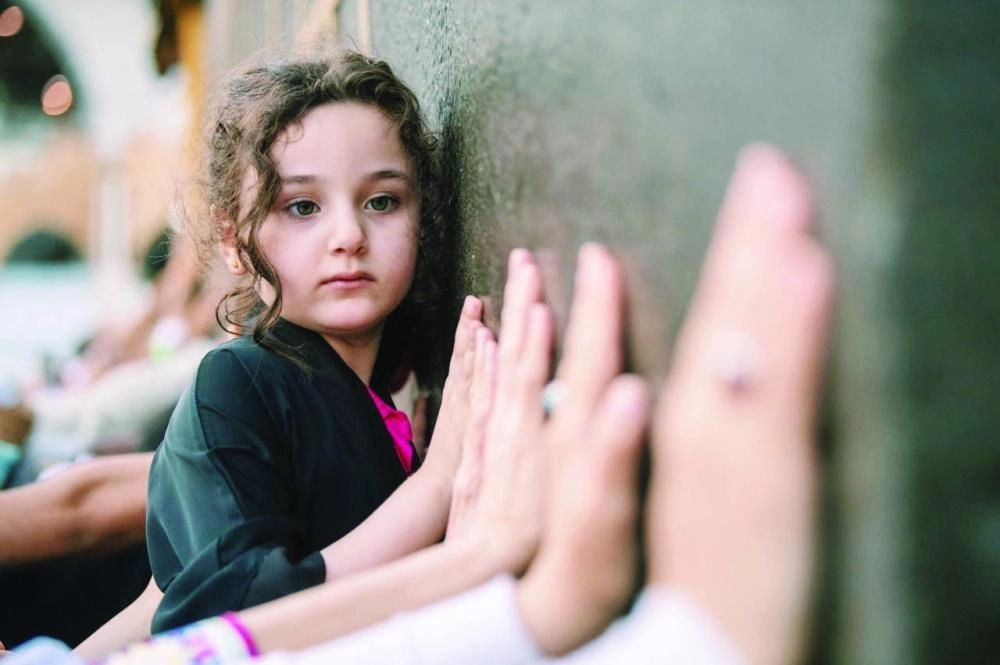 



الطفلة أثناء تعلقها بالكعبة المشرفة                                                                            (مكة)