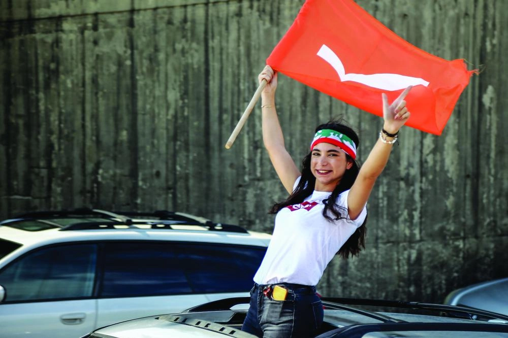 لبنانية ترفع العلم مع استمرار المظاهرات (د ب أ)