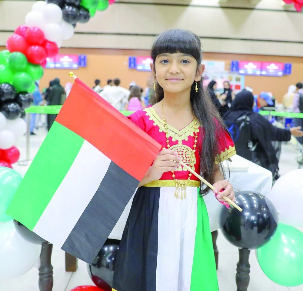 فتاة سعودية تستقبل الإماراتيين بالأعلام والهدايا (واس)