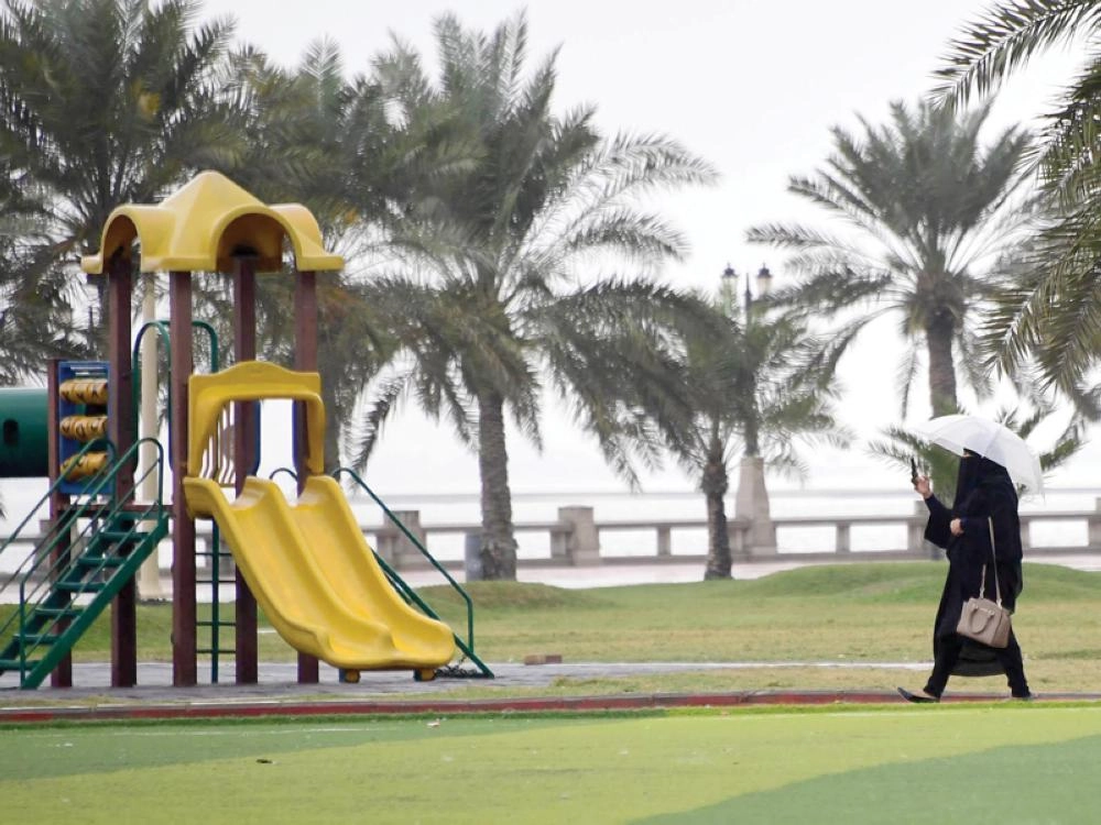 امرأة تحتمي بمظلة مع هطول أمطار على المنطقة الشرقية (واس)