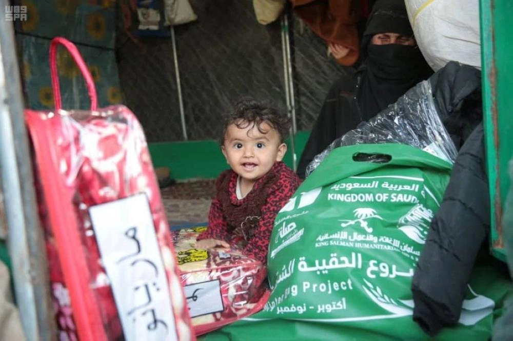 طفل ووالدته يتوسطان الحقائب الشتوية (واس)