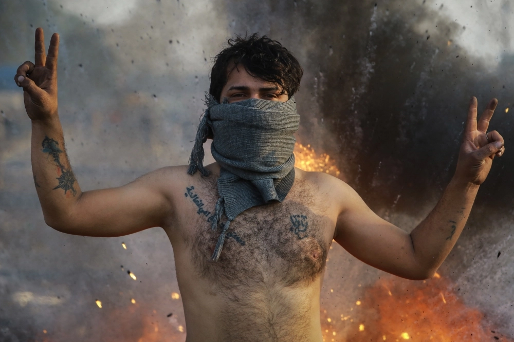 متظاهر عراقي يرفع علامة النصر (د ب أ)