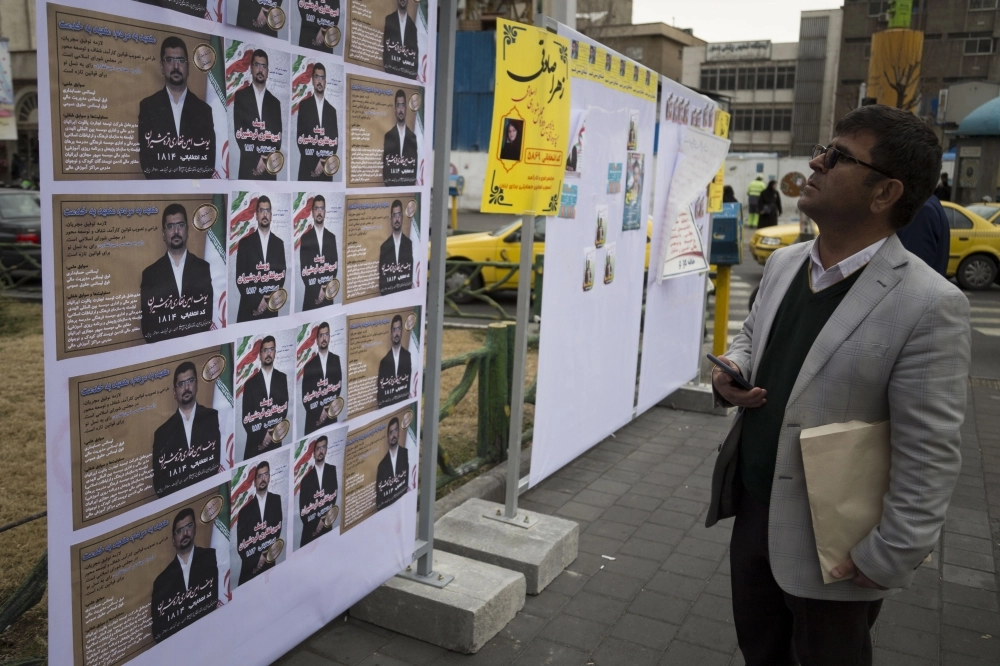 






إيراني يقرأ البرامج الانتخابية                                                 (د ب أ)