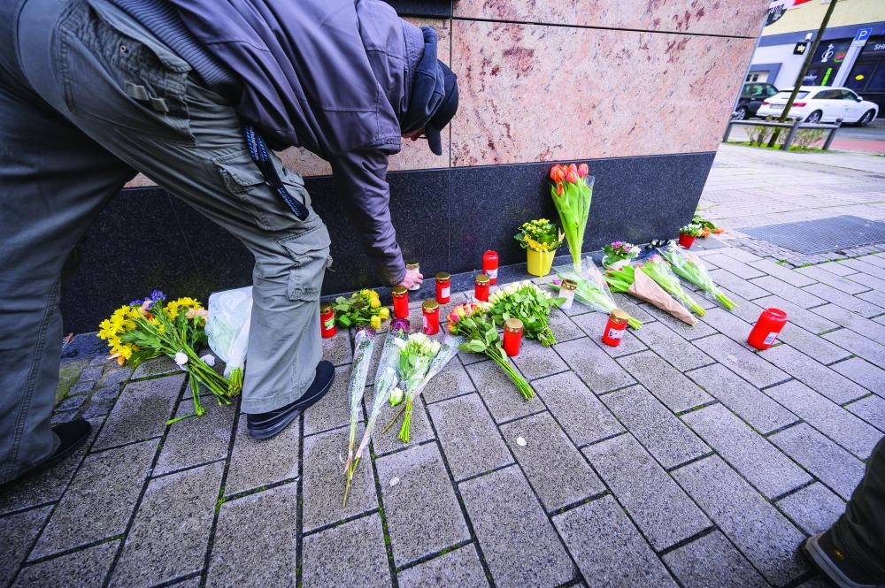 رجل يضع زهورا بالقرب من ضحايا هاناو (د ب أ)