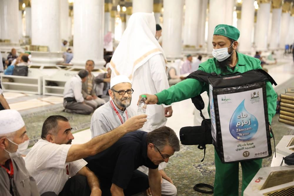 توزيع مياه زمزم على المصلين ( تصوير - احمد القثمي )