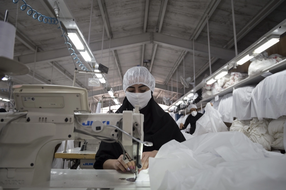 عاملة ايرانية تعمل في حياكة الملابس (د ب أ)