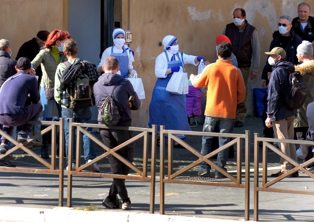 سيدتان توزعان طعاما على الفقراء في روما   (د ب أ)