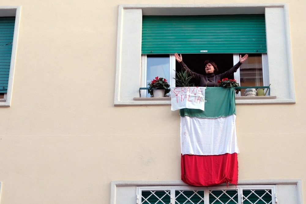 



أسرة إيطالية تنظر من النافذة في ظل منع التجوال (د ب أ)