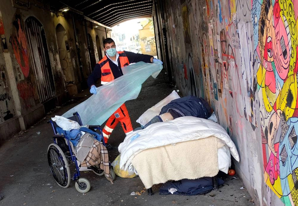  مسعف يغطي جثة شخص بلا مأوى تم العثور عليه ميتا في ايطاليا (د ب أ)