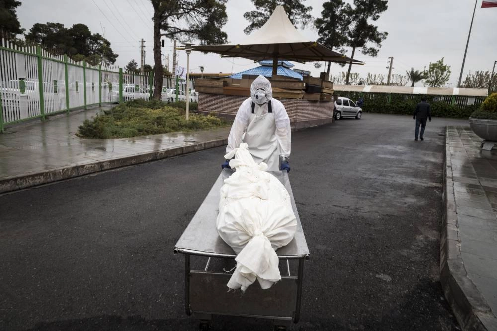 






عملية دفن أحد المتوفين من كورونا في إيران               (د ب أ)