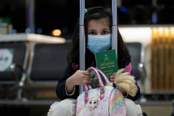 طفلة تحمل الجواز السعودي بعد عودتها إلى المملكة