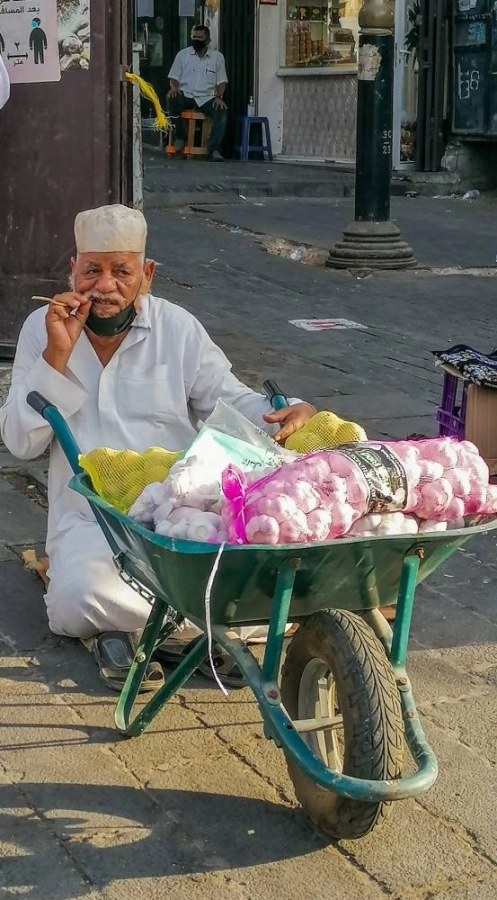 أحد المسنين يستخدم إحدى العربات الصغيرة لبيع بضاعته البسيطة من الثوم والبطاطس في أحد الأسواق الشعبية بجدة. (أنس الحارثي) 