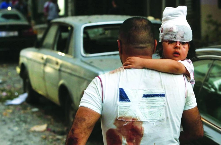 أحد المتضررين يحمل ابنته وسط أشلاء بيروت (د ب أ)