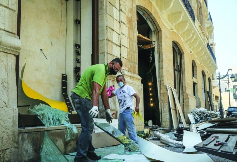 عاملان يحاولان لملمة اثار الدمار (د ب أ)