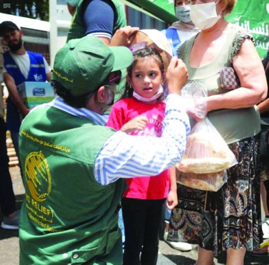 






أحد أفراد المركز يداعب طفلة لبنانية صغيرة                                     (واس)