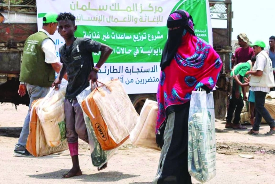 امرأة وابنها يحملان مواد إيوائية (واس)