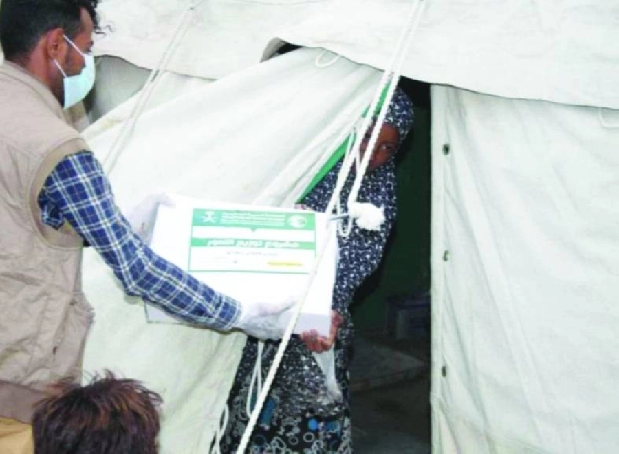 يمنية تتحصل على كرتون تمر من مركز الملك سلمان للإغاثة (واس)