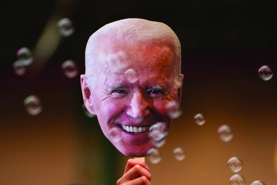 أحد الامريكيين يحتفل بلوحة عليها صورة بايدن (د ب أ)