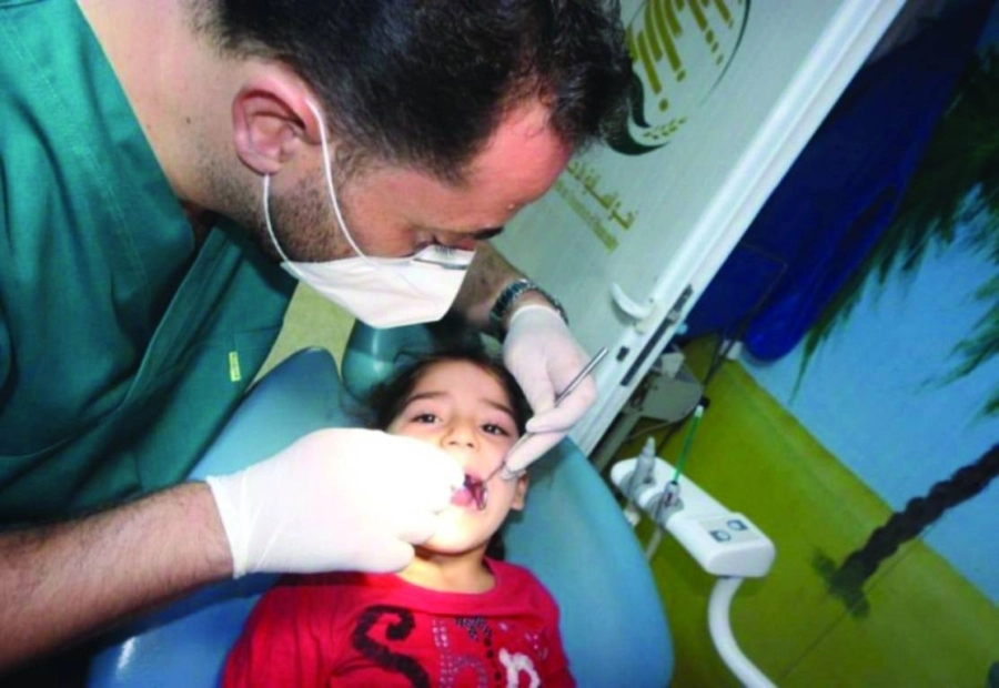 الطبيب يكشف على أسنان طفلة سورية (واس)