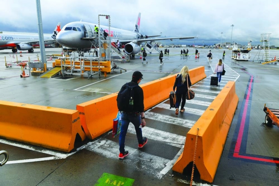 ركاب خلال صعودهم طائرة متجهة من ملبورن إلى سيدني بعد أربعة أشهر من الإغلاق
