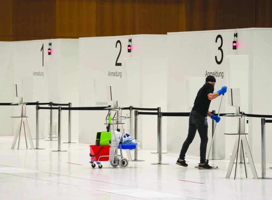 عامل ينظف الأرضية داخل مركز مؤتمرات في ألمانيا مجهز بالكامل وجاهز لبدء التطعيم ضد فيروس كورونا
