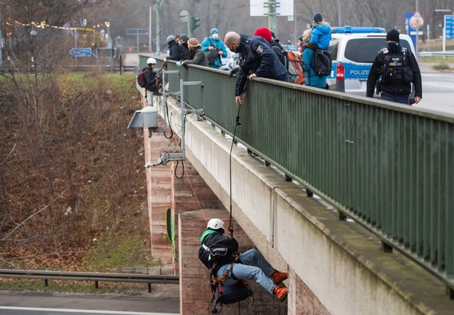 نشطاء في برلين يهبطون من جسر سبينر أثناء احتجاج دراجات ضد توسع الطرق مطالبين بالامتثال لأهداف المناخ الباريسية.
