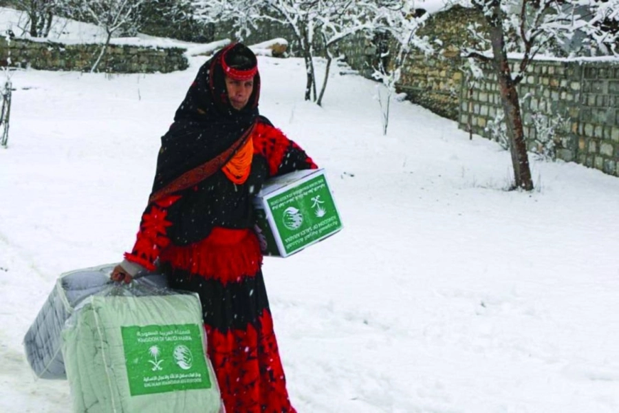 امرأة باكستانية تحمل السلال والبطاطين (واس)