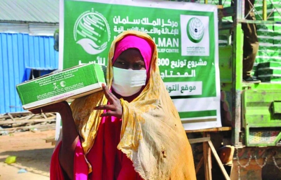 سيدة تشير نحو كرتون التمور (واس)