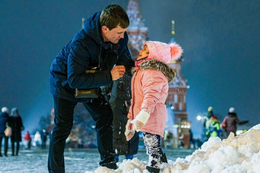 رجل يلعب مع طفله بالثلج في الميدان الأحمر في موسكو بروسيا
