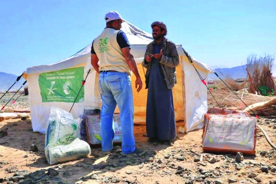 متطوع يساعد أحد اللاجئين             (واس)