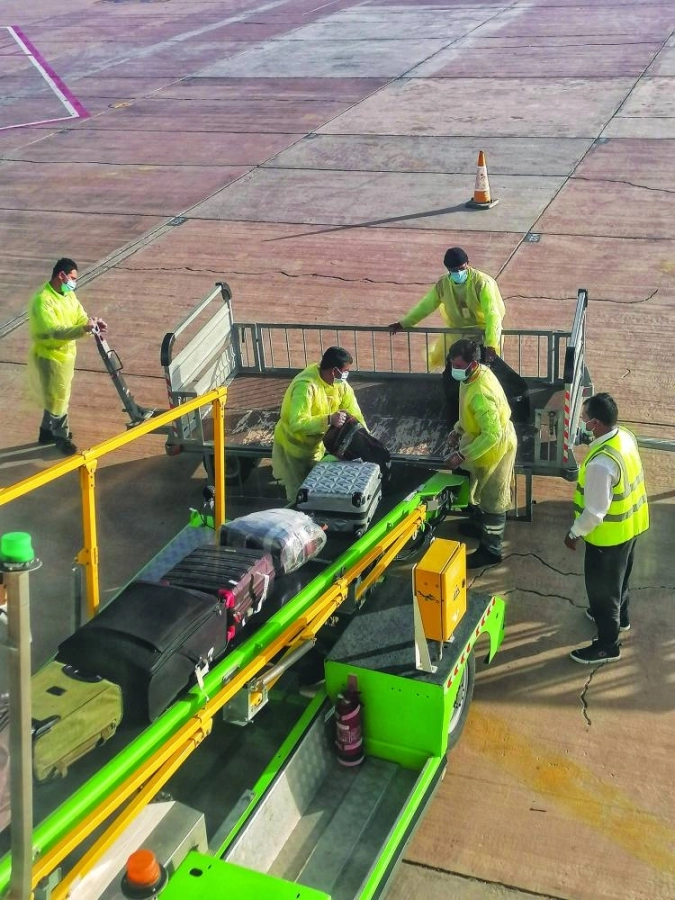 من الاحترازات المطبقة خلال أزمة كورونا للتعامل مع أمتعة ركاب إحدى الرحلات. (أنس الحارثي)