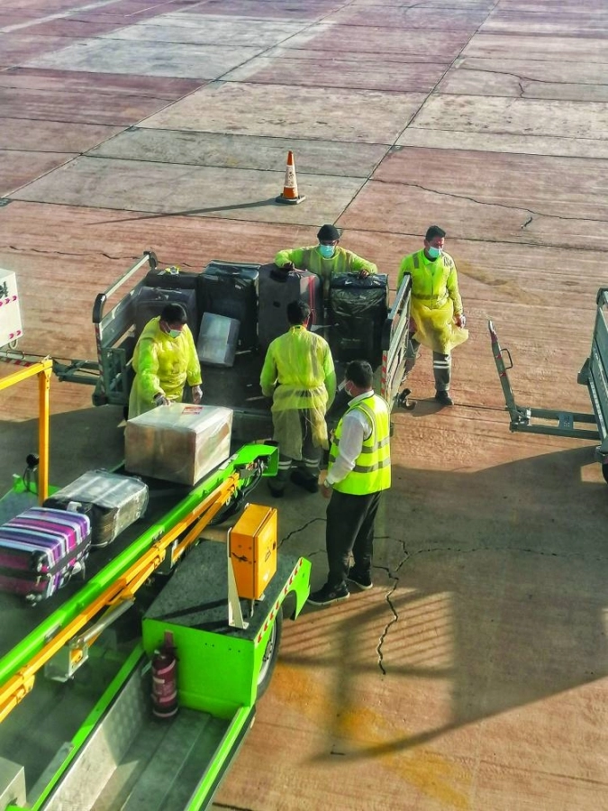 من الاحترازات المطبقة خلال أزمة كورونا للتعامل مع أمتعة ركاب إحدى الرحلات. (أنس الحارثي)