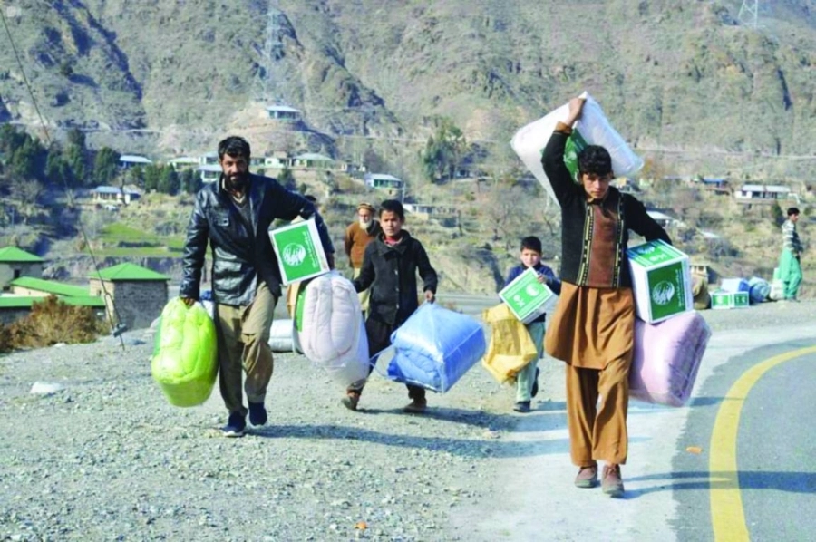 باكستانيون يحملون هداياهم من البطاطين والمواد الغذائية (مكة)