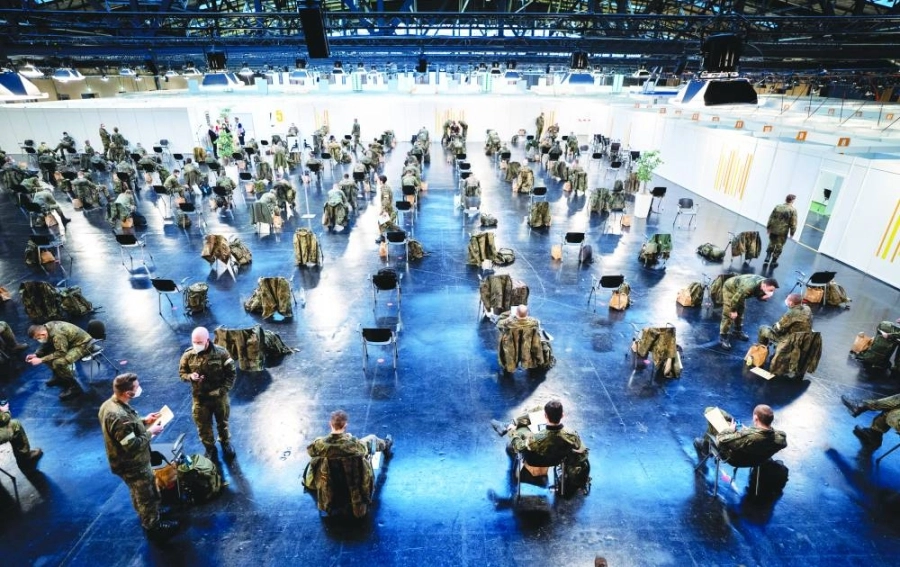 جنود من القوات المسلحة الألمانية يرتدون أقنعة للوجه ينتظرون بدء التشغيل التجريبي في مركز التطعيم ضد كورونا في برلين اعتبارا من 27 ديسمبر الجاري.
