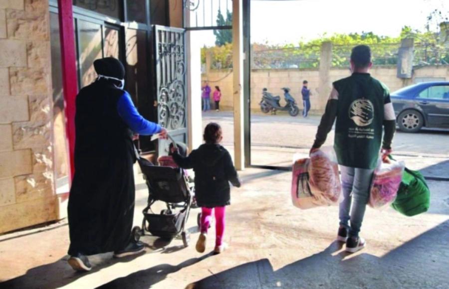 أسرة تحصل على الاحتياجات الشتوية بمساعدة متطوع (واس)