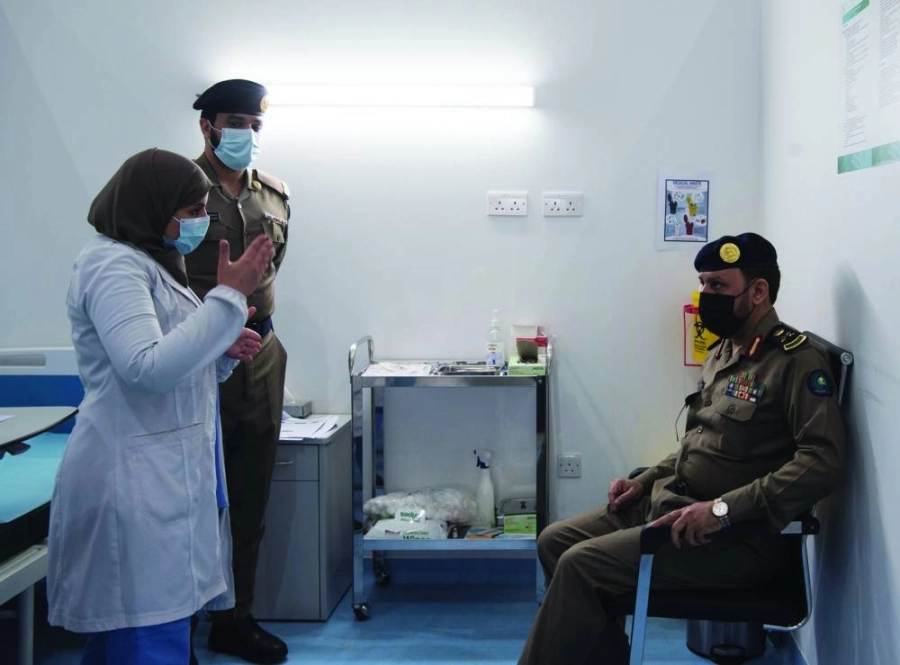 رجلا أمن يستمعان لشرح عن التطعيم باللقاح              (مكة)