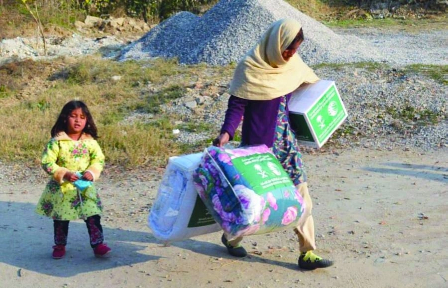 سيدة باكستانية تحمل حقيبة الشتاء السعودية (واس)