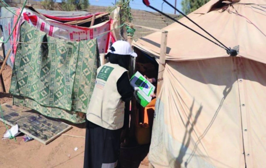 متطوعة توصل كرتونا إلى خيمة نازحين                                                (واس)