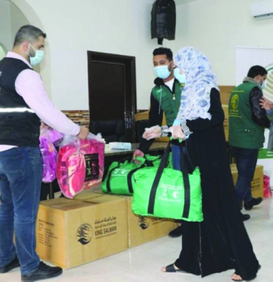 سيدة أردنية تتسلم حقيبة شتوية سعودية        (واس)