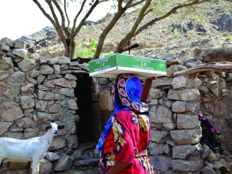 يمنية تحمل كرتون التمور (واس)