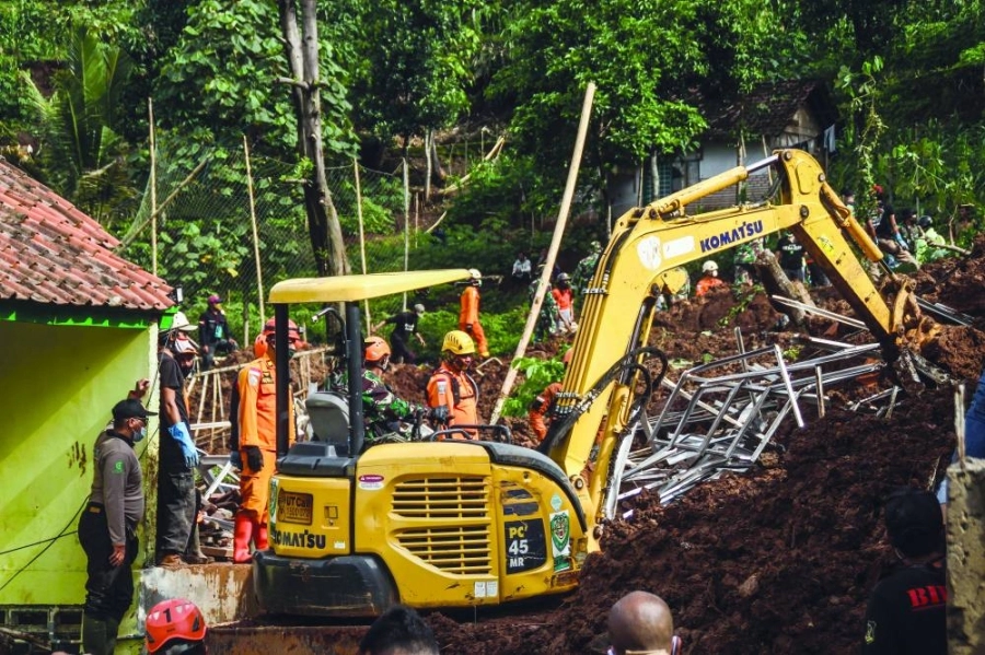 فريق إنقاذ يبحث عن جثث الضحايا أو الناجين الذين دفنوا بسبب الانهيار الأرضي الذي حدث بسبب هطول الأمطار الغزيرة وعدم استقرار التربة في إندونيسيا 
