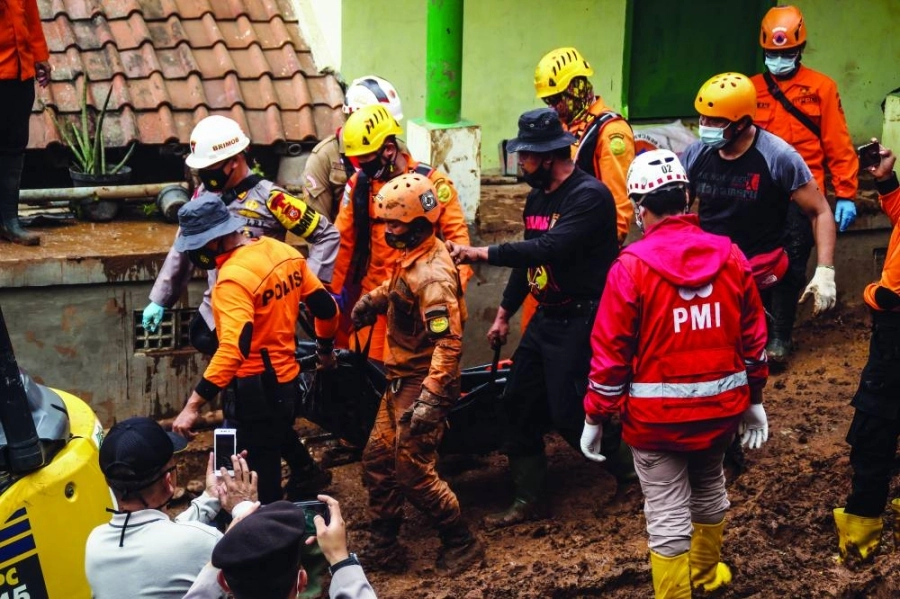 فريق إنقاذ يبحث عن جثث الضحايا أو الناجين الذين دفنوا بسبب الانهيار الأرضي الذي حدث بسبب هطول الأمطار الغزيرة وعدم استقرار التربة في إندونيسيا 

