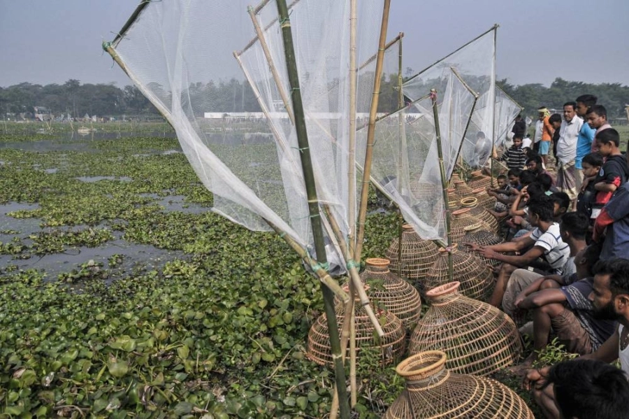 صيادون يجتمعون بشباكهم التقليدية عند أحد الأنهار لحضور مهرجان صيد الأسماك التقليدي في بنجلاديش
