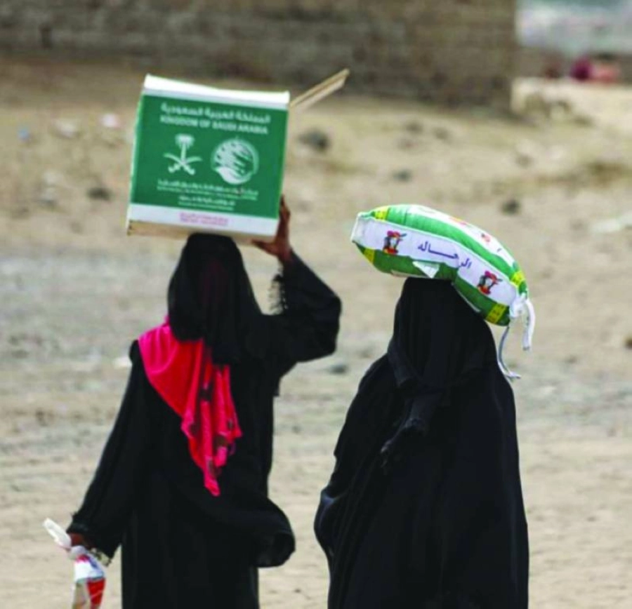 يمنيتان تحملان مساعدات مركز المك سلمان للاغاثة (واس)