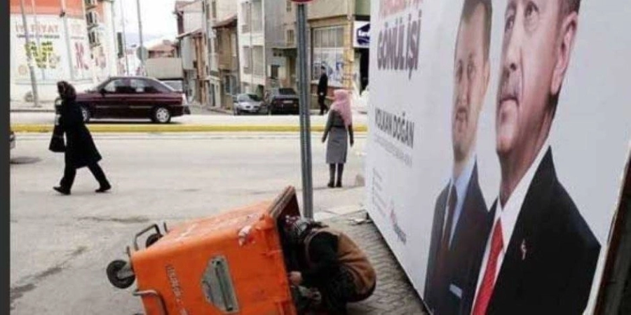 تركية تبحث في القمامة بجوار صورة إردوغان (مكة)