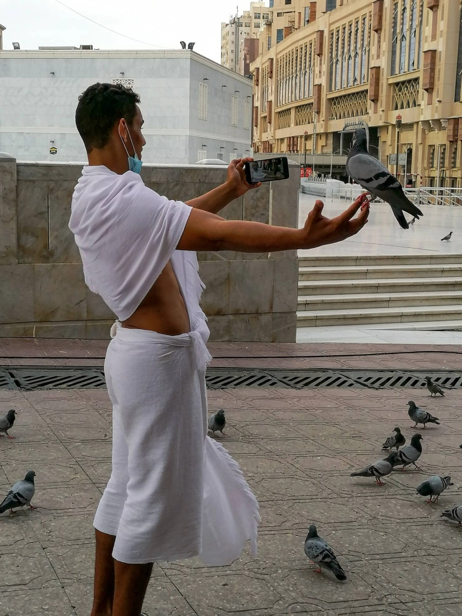 حرص المعتمرون في أول أيام رمضان على إطعام الحمام والتقاط الصور التذكارية (أنس الحارثي) 