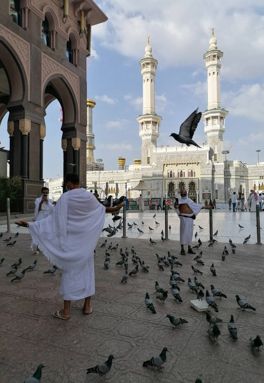 حرص المعتمرون في أول أيام رمضان على إطعام الحمام والتقاط الصور التذكارية (أنس الحارثي) 