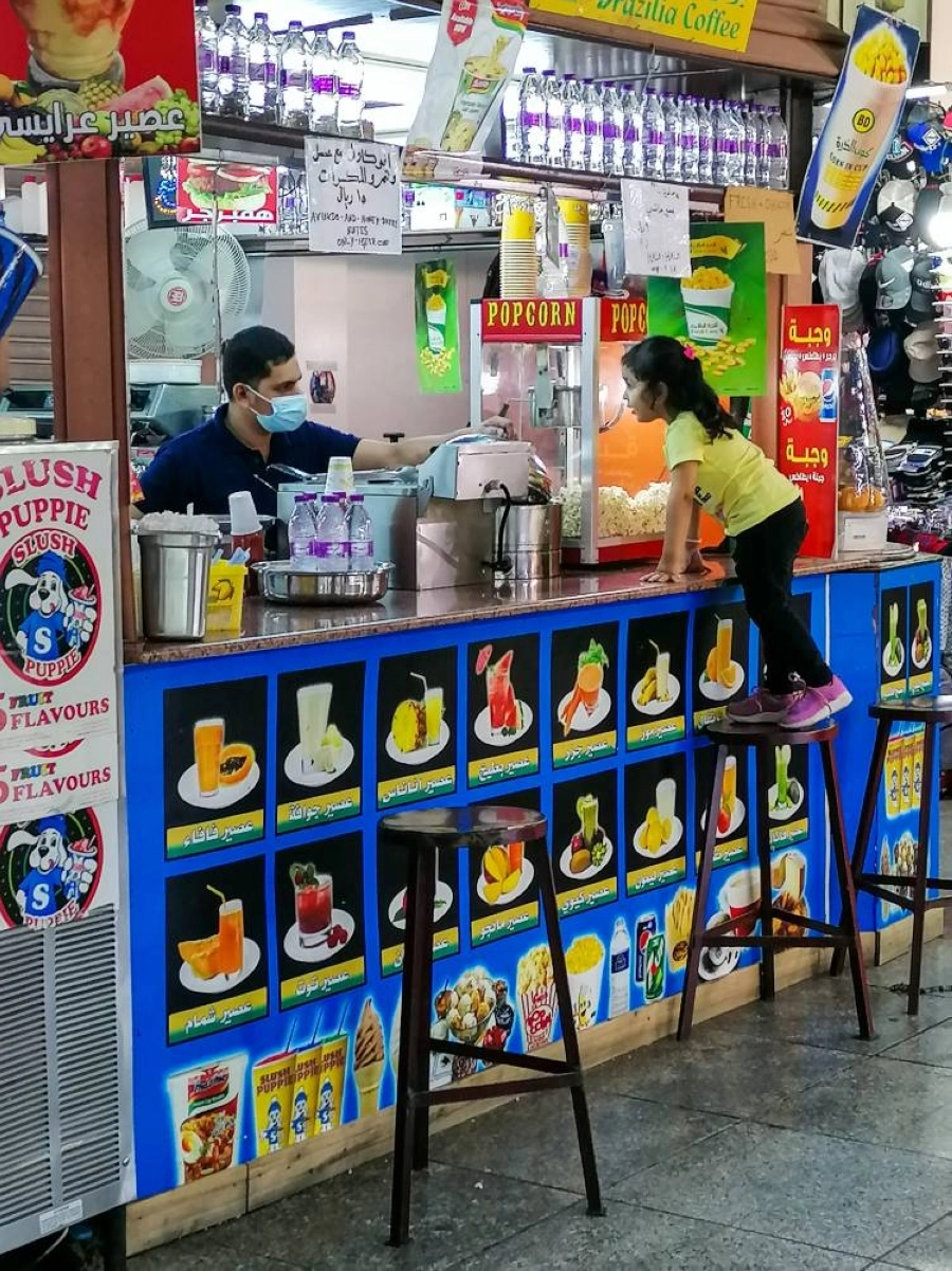 دفع الشغف بالحلوى طفلة لمغافلة أسرتها وتسلق أحد كراسي المحلات لمحاورة البائع وطلب حلوى قبل أن تصطادها أعين والديها.
